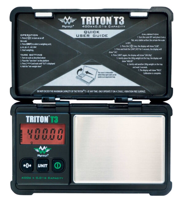 No augšas fotografēti atvērti MyWeigh Triton T3 svari ar spīdošu sarkanu digitālo ekrānu, nerūsējošā tērauda svēršanas platformu un īsu lietošanas instrukciju, kas uzdrukāta vāciņa iekšpusē